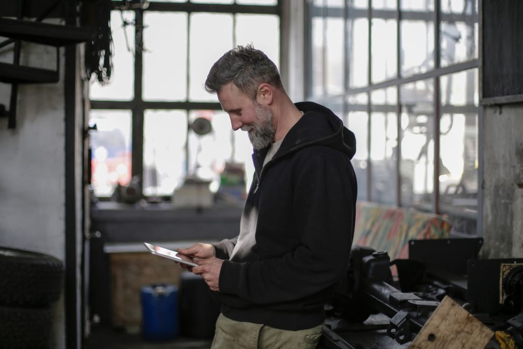 Workshop technician using a tablet near a workbench for capacity planning workflow review